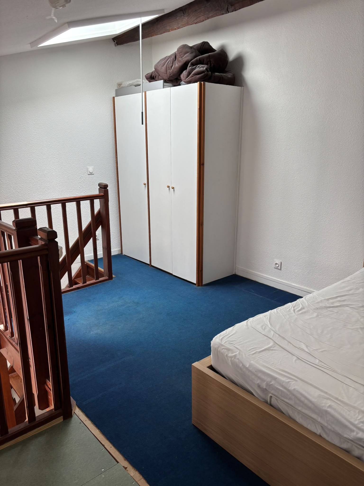 Mezzanine avant rénovation avec moquette bleue et ancien rangement