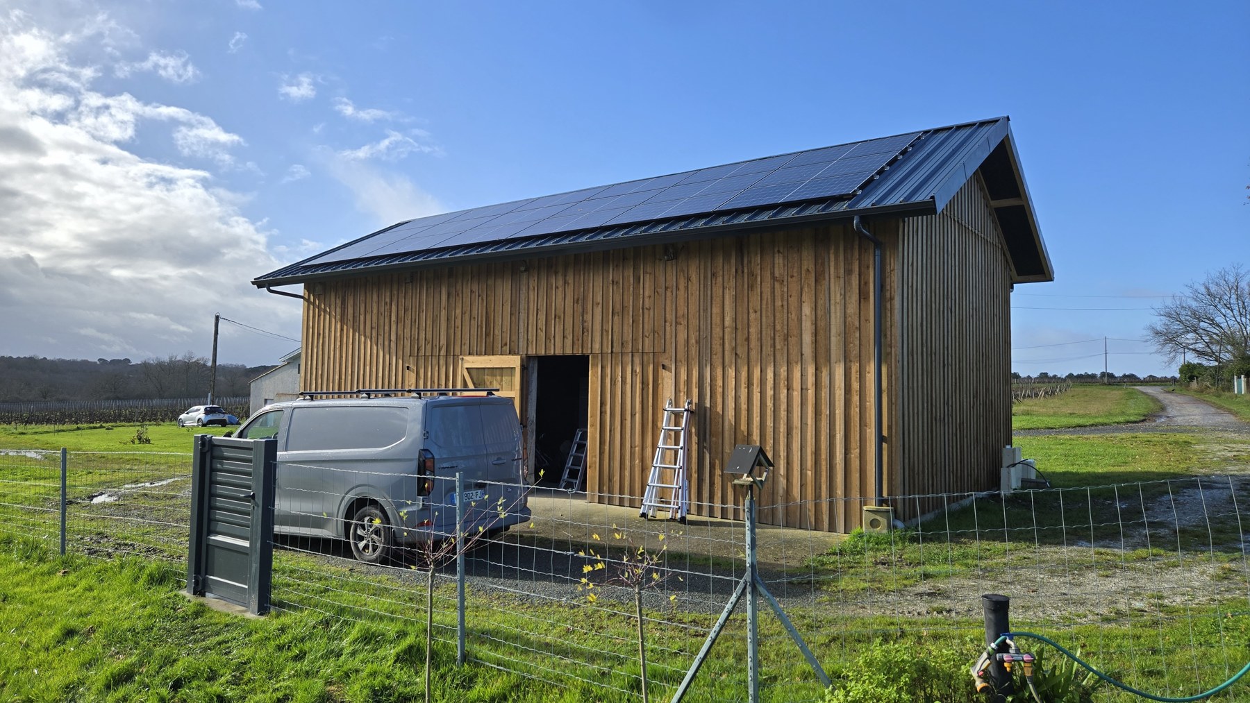 Panneaux photovoltaïques posés sur la toiture d’un bâtiment à bardage bois